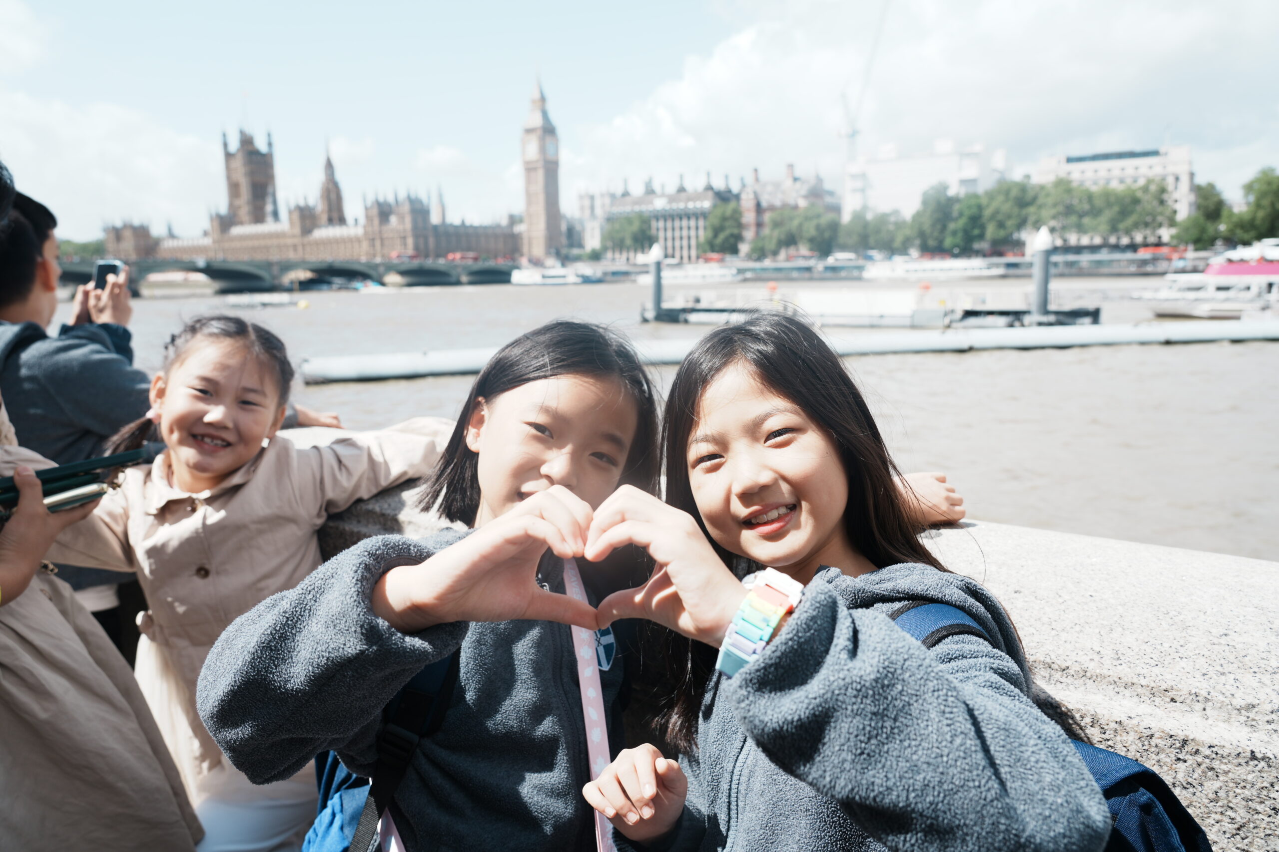 a group of girls making a heart with their hands