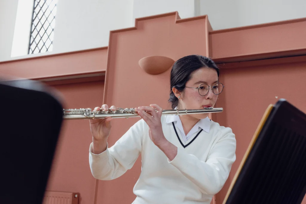 A young female student playing a flute at The King's Summer School's Music and Performance Academy.
