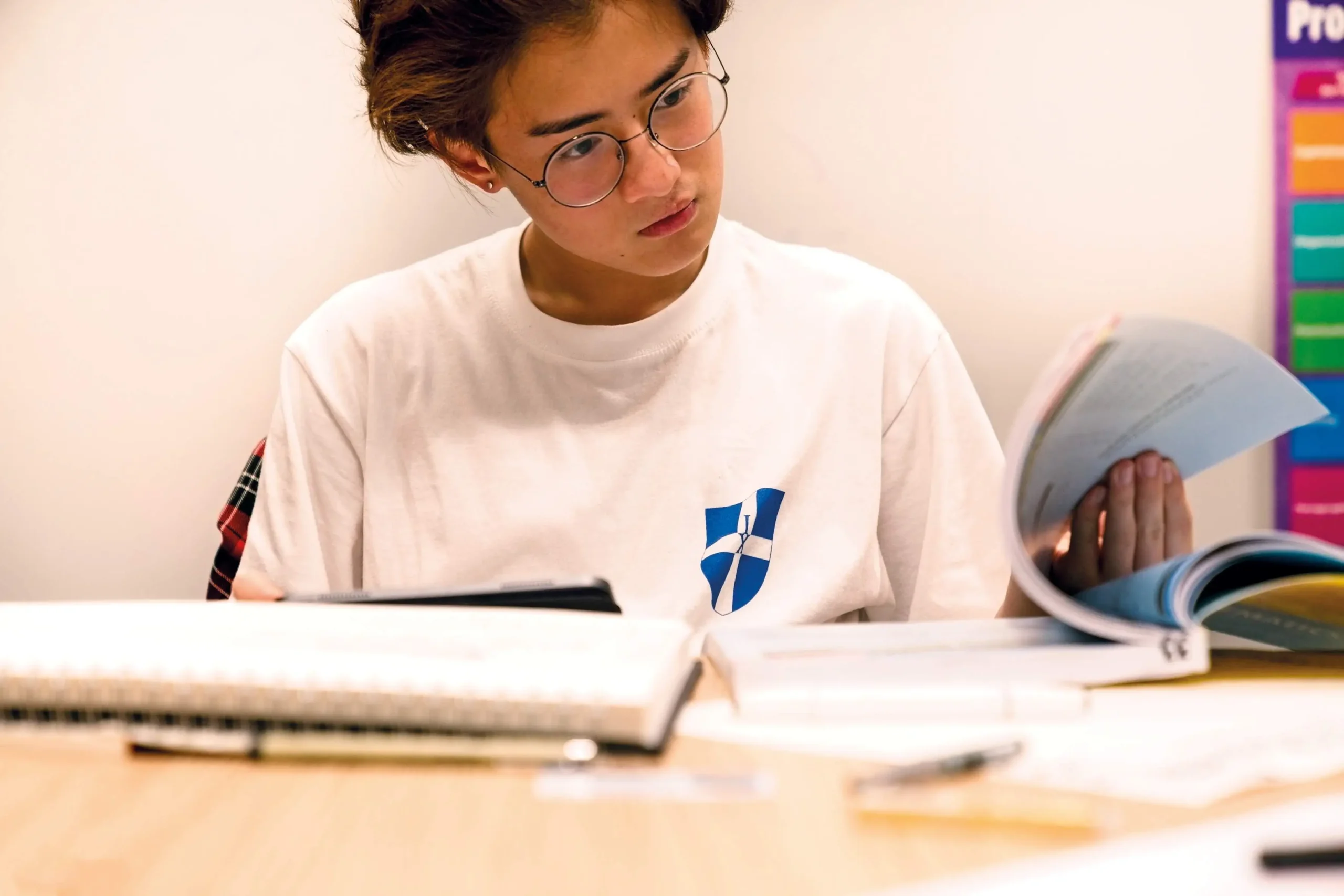 A young student in uniform studying a workbook at The King's Summer School’s International Relations Academy